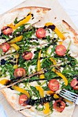 A vegetable pizza with rocket, cherry tomatoes and pepper