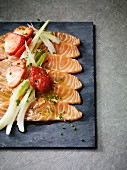 Salmon carpaccio with spring onions and strawberries