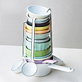 A stack of soup bowls, ladles and saucepans