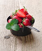 Fresh strawberries with leaves in a saucepan