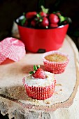 Cheesecake cupcakes with icing sugar and strawberries