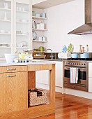 Island counter with wooden base unit in corner of modern kitchen