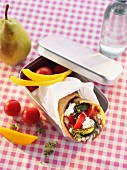 A vegetable wrap in a lunch box