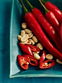 Fresh red chilli peppers and peanuts (seen from above)