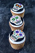 Three cupcakes decorated with skulls for Halloween