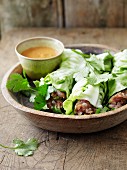 Lettuce wraps filled with raw minced pork with herbs and served with a dip
