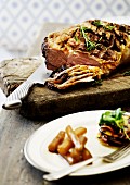 Crispy roast beef with a mustard crust on a chopping board, partially sliced