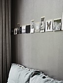 Black and white photos on grey-painted wall above sofa with various decorative buttons