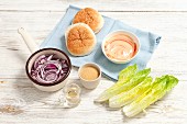 Ingredients for hamburgers: red onions, sugar, vinegar, mayonnaise with ketchup and cos lettuce