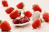 Ein Löffel Erdbeermarmelade und frische Erdbeeren