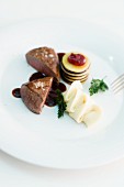 Saddle of venison with a dark sauce, mashed potatoes and an apple and cranberry tower