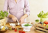 Fresh fruit and vegetables and a woman slicing mushrooms