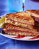 A toasted sandwich with pastrami, cheese and sauerkraut