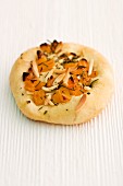 Focaccia with apricots, almonds and rosemary on a wooden surface