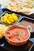 Chicken Tikka Masala with curried potatoes, rice, and lentils with naan bread (India)