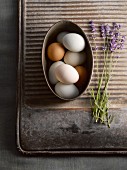 Eggs in metal bowl next to lavender