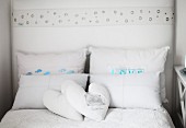 Double bed with heart-shaped scatter cushions and stacked pillows in rustic atmosphere