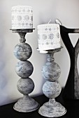 Christmas candles decorated with silver glitter on metal candlesticks