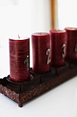 Dark red Advent candles in rusty, rectangular candelabra