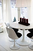 Tulip chairs around Advent candelabra on round table in window bay