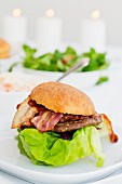 A hamburger with bacon and lettuce