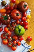 Various types of tomatoes on a tea towel
