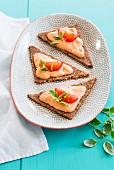 Bread triangles topped with ricotta and tomato cream and basil