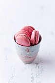 Pink macaroons in a ceramic cup