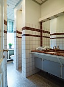 Blick durch offene Tür in Badezimmer, Einbau Waschtisch mit Steinplatte, neben gemauertem Duschbereich