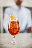 A glass of Aperol Spritz on a marble table