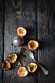 Whole and hollowed out passion fruits on a wooden surface
