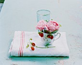 Peonies and wild strawberries in teacup