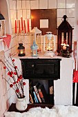 Red candles in candlestick and vintage lanterns on masonry stove