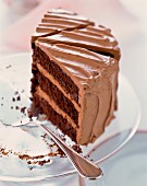 Three slices of chocolate cream cake on a cake plate