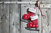 Pair of textile ice skate decorations hanging on wooden door