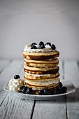 A stack of pancakes with blueberries and cream