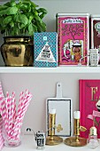 Feminine arrangement of kitchen shelves with pink accents and brass ornaments