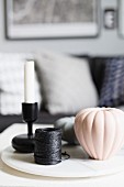 Arrangement of reel of charcoal cord, pumpkin-shaped vase and candlestick on board