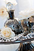 Dekorative Flasche in Bauernsilber-Optik, Rose und Perlenkette auf Tortenplatte