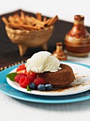 A mini chocolate cake with cinnamon, vanilla ice cream and fresh berries