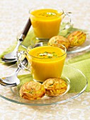 Two glasses of curry soup with savoury pastries