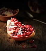 A piece of pomegranate on a wooden surface