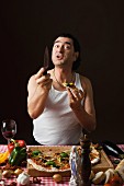 Typisch italienischer Mann mit Messer und Pizza