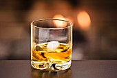 A glass of whisky with ice cubes