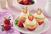 Strawberry muffins with a mascarpone topping on a white plate