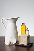 Aromatherapy oil, soap, a pitcher and an orchid flower