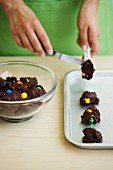 Chocolate biscuits with colourful chocolate beans being made