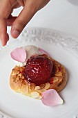 A choux pastry ring with glazed plums and rose cream