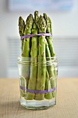 Keeping asparagus fresh: green asparagus spears in a glass with a little water