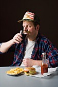 Typisch amerikanischer Mann mit einer Fast-Food-Mahlzeit